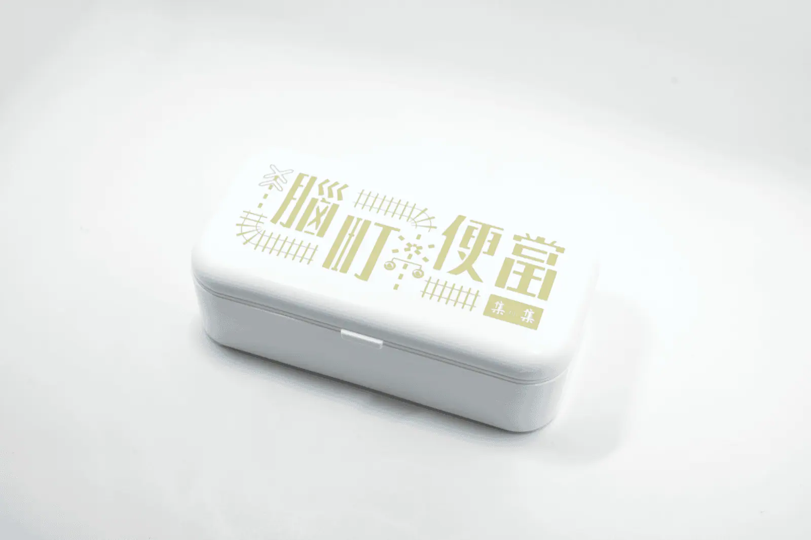 腦町便當文創商品主視覺，白色便當盒印有集集鐵道意象標準字｜好心地文創