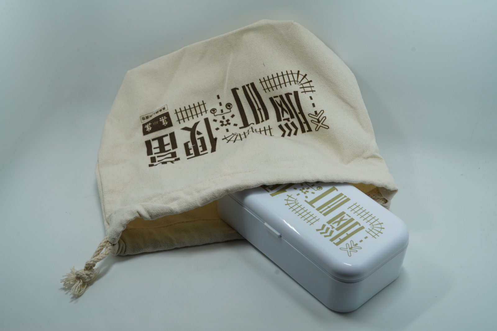 帆布提袋「腦町便當」標準字特寫，枕木與平交道圖騰
