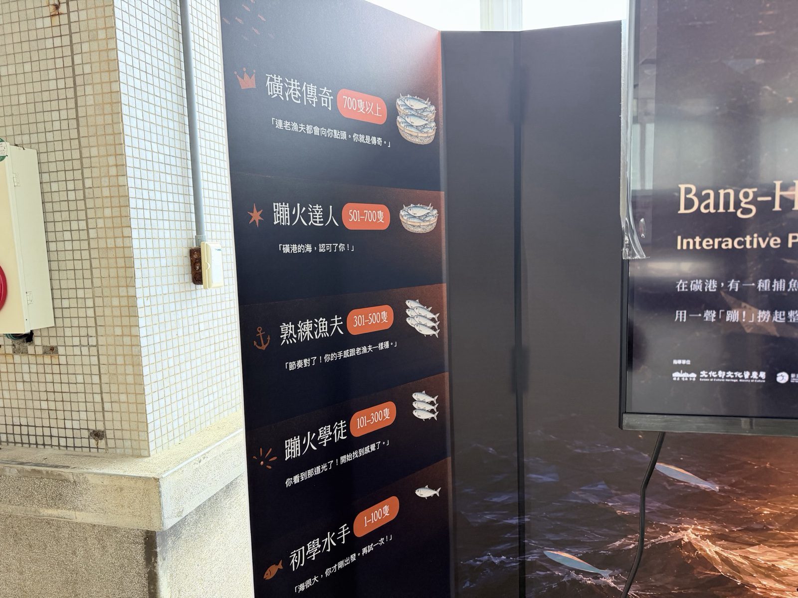 核心互動裝置螢幕顯示《磺火拾光》主視覺畫面，右側為蹦火等級說明展板