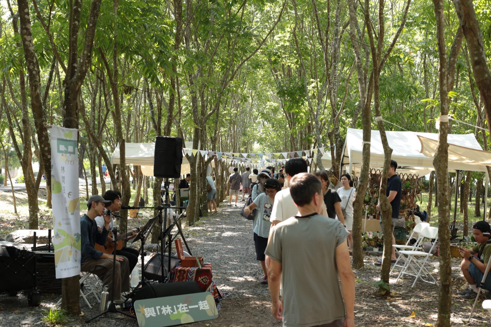 林間日和市現場實景，親子遊客走過旗幟裝飾的市集步道