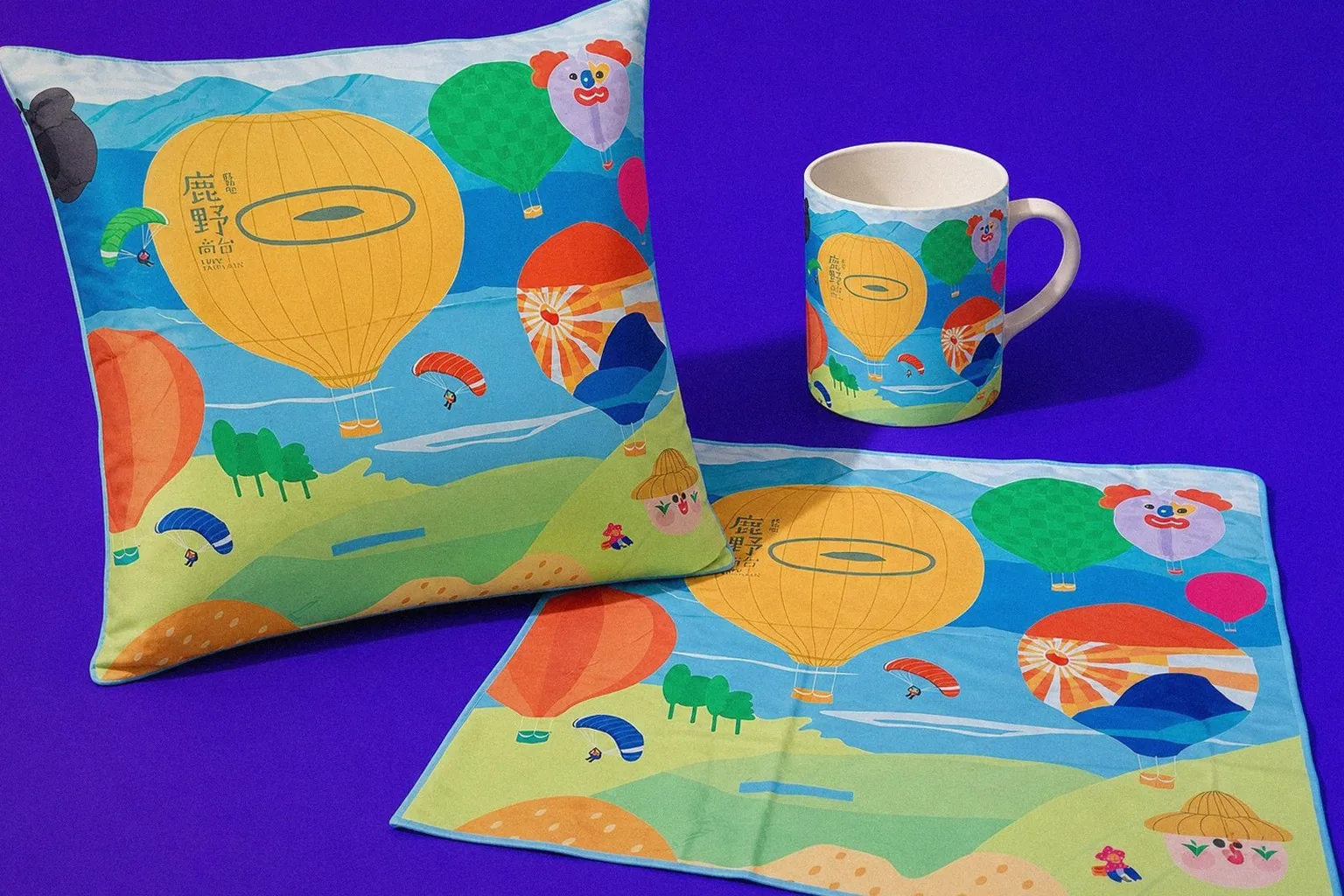 Luye Highland hot air balloon graphic applications on display: picnic mat, cushion, mug | Howdy Creative